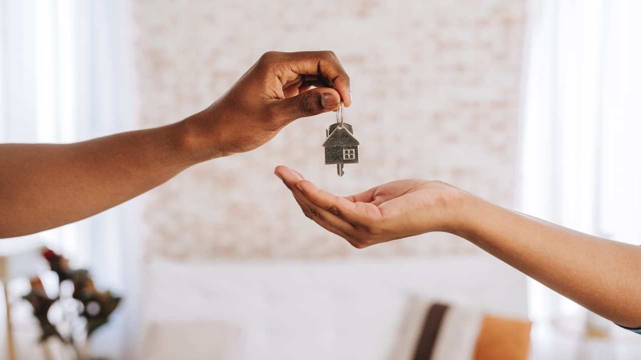 En la foto: 2 personas entregando llaves de una casa