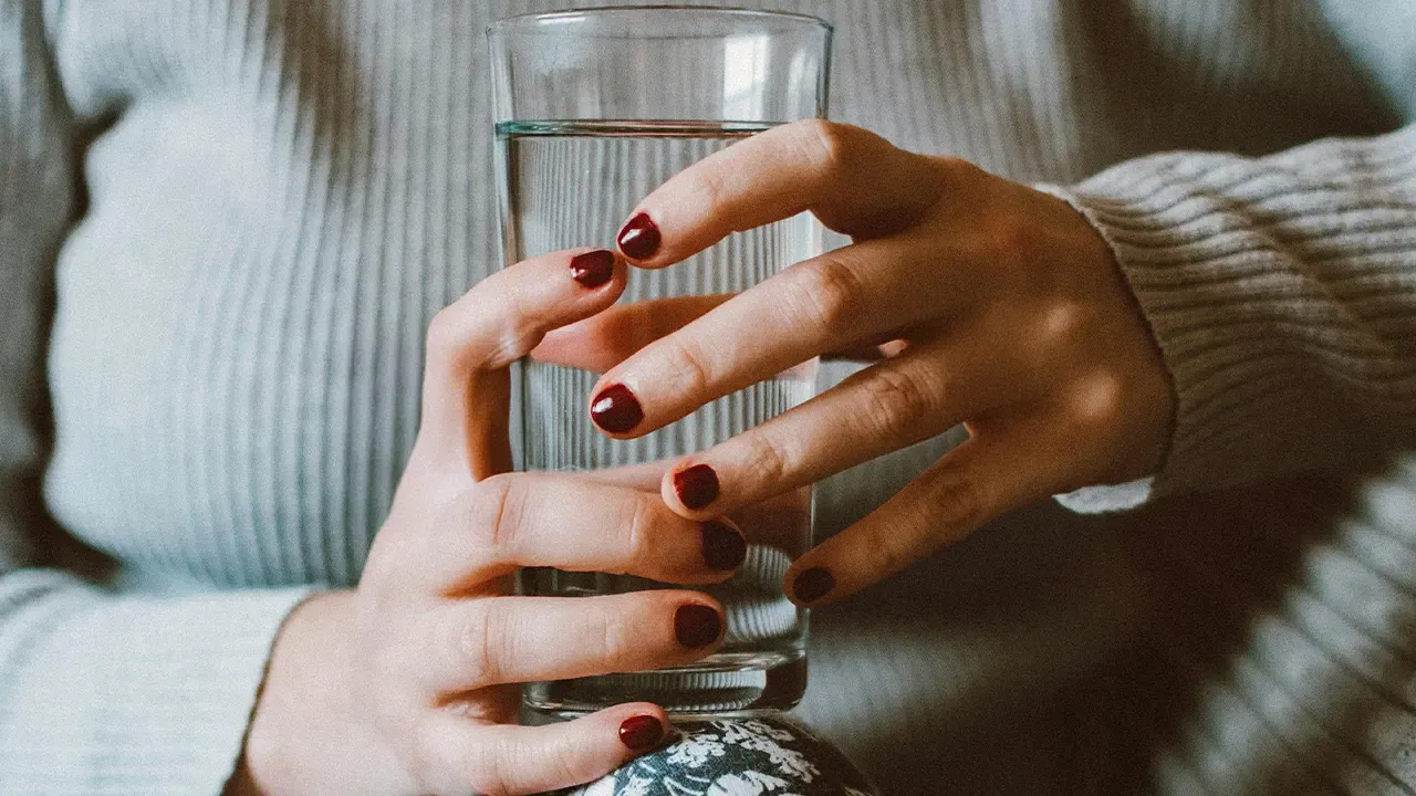 En la foto: Mujer con un vaso de agua