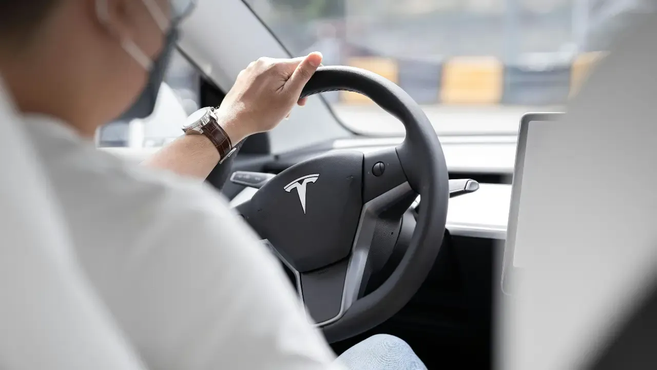 En la foto: Hombre conduciendo un TESLA