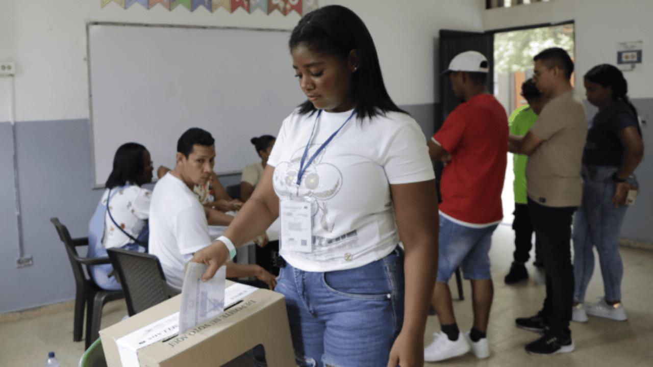 Mujer deposita un voto en las urnas de la Registraduría
