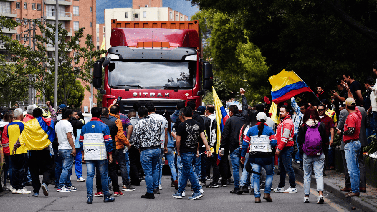 Manifestantes frente a un camión de carga.