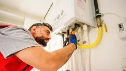 En la foto: Hombre revisando calentador de agua