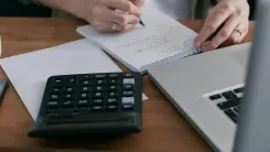 En la foto: Escritorio con computador y una calculadora