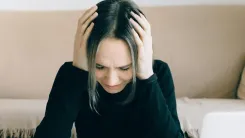 En la foto: Mujer con las manos en la cabeza expresión preocupada.